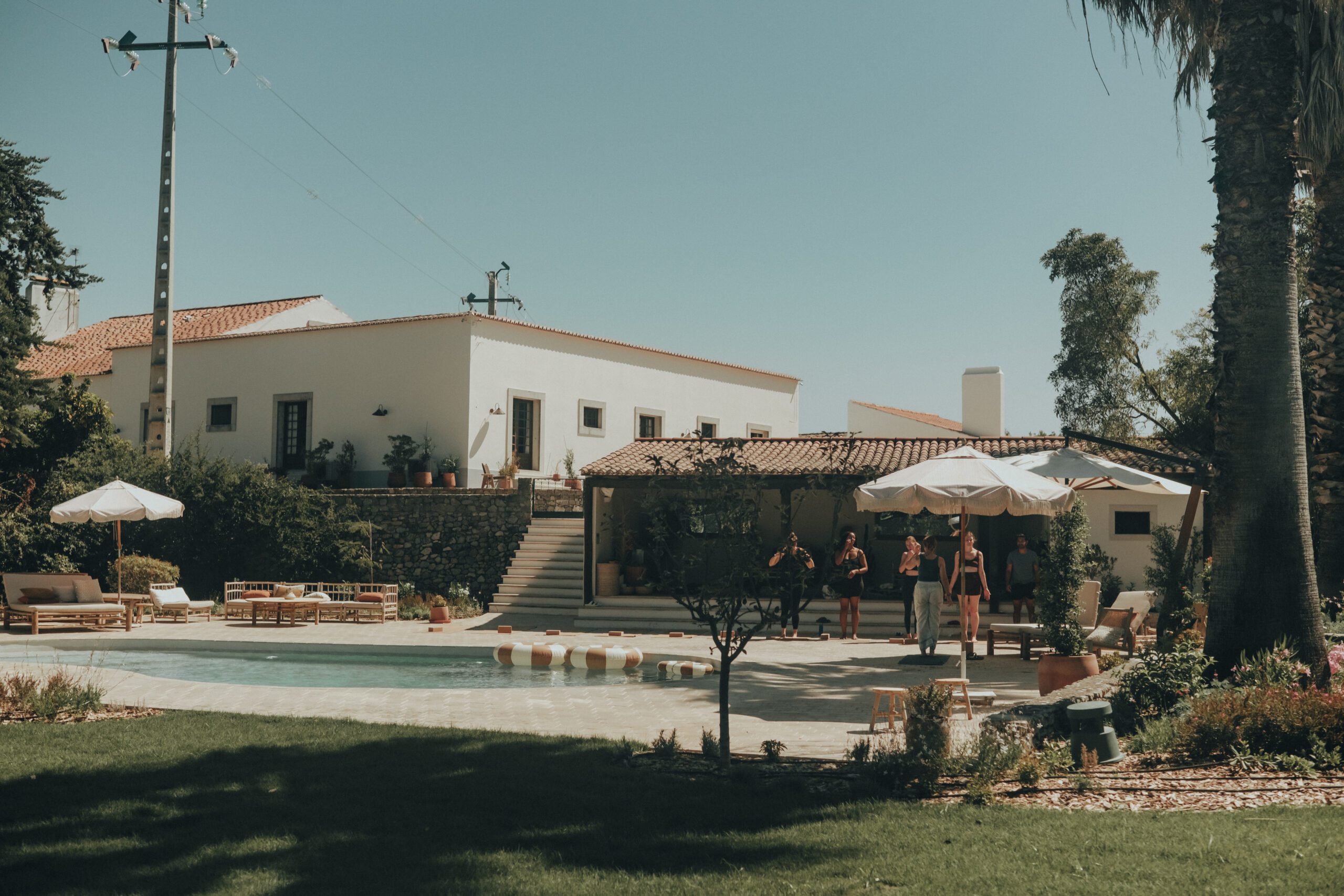 Sunny villa with pool and lounging area, surrounded by greenery, perfect for relaxing and entertaining guests.